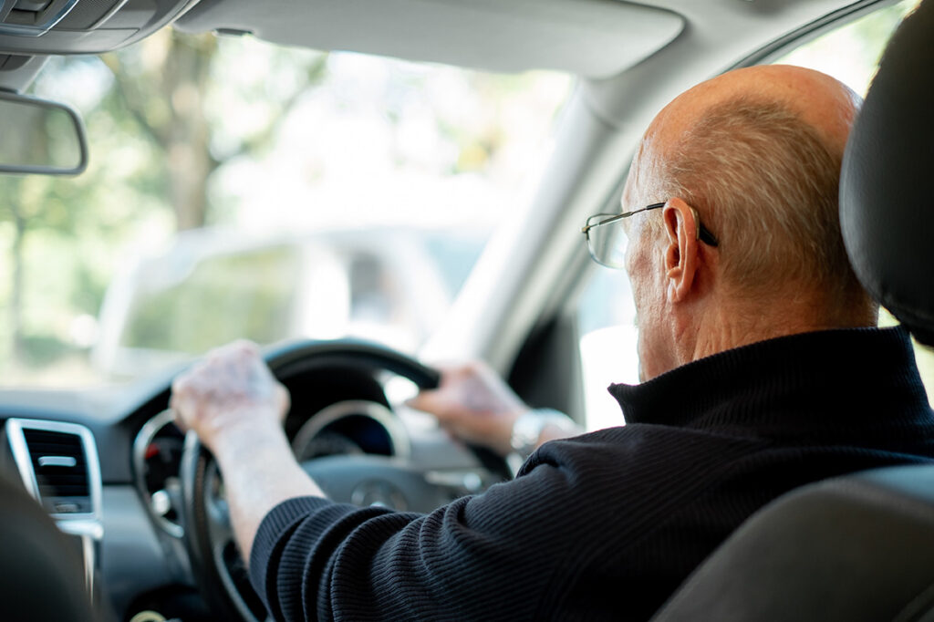 Old man driving vehicle